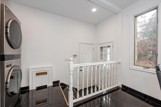 stairway featuring stacked washer and clothes dryer