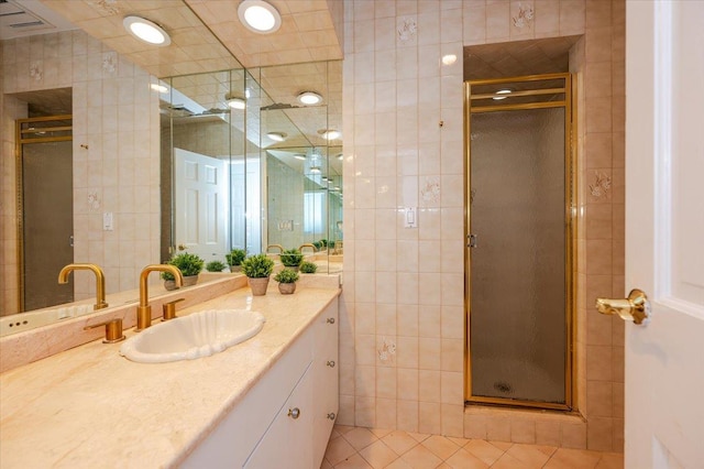 bathroom featuring tile patterned flooring, vanity, tile walls, and walk in shower