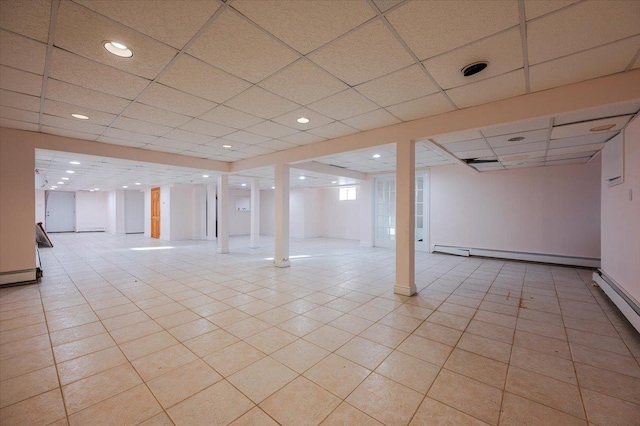 basement featuring a drop ceiling and a baseboard radiator