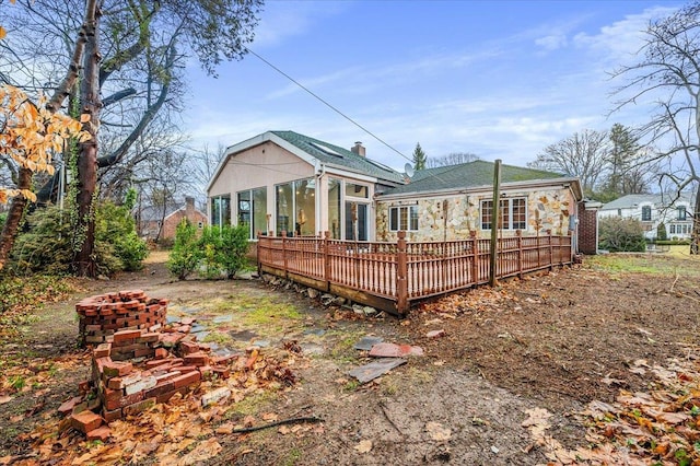 back of house with a wooden deck and a sunroom