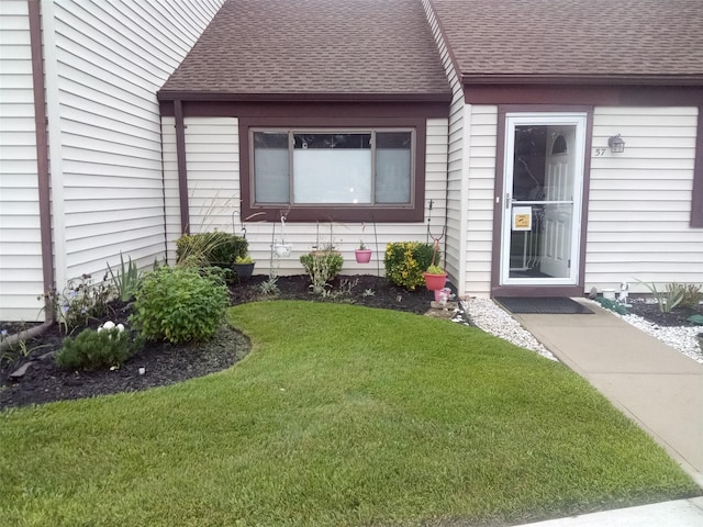 view of exterior entry featuring a lawn