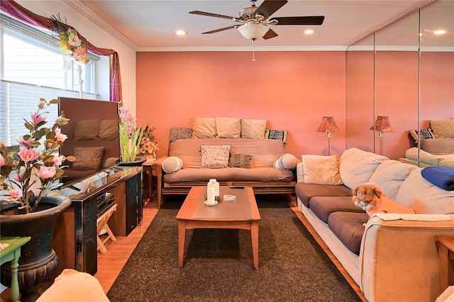 living room with hardwood / wood-style flooring, ceiling fan, and crown molding