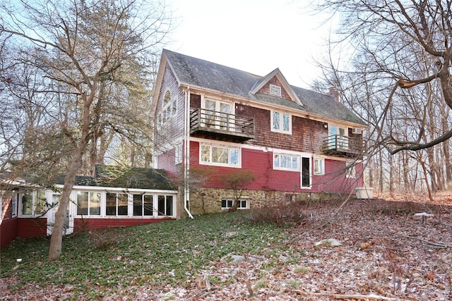 view of property exterior featuring a sunroom and a balcony