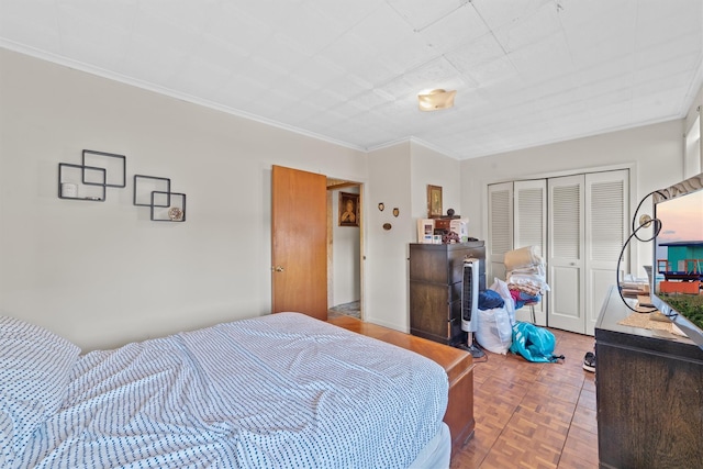 bedroom featuring parquet flooring, ornamental molding, and a closet