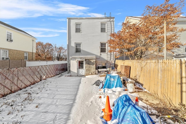 snow covered property with cooling unit