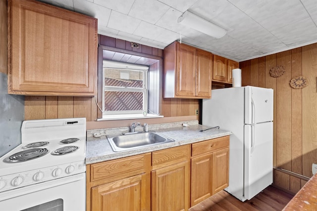 kitchen with wood walls, sink, hardwood / wood-style floors, and white appliances