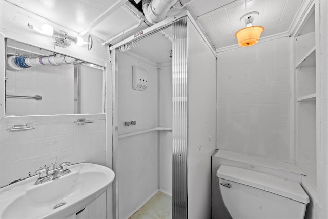 bathroom with toilet, tile walls, crown molding, and sink