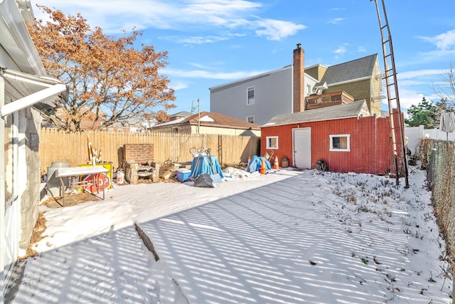 snow covered property with a storage unit