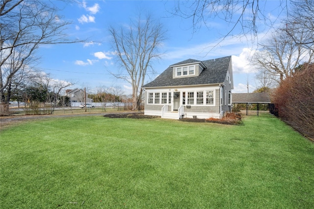 back of property with a lawn and a carport