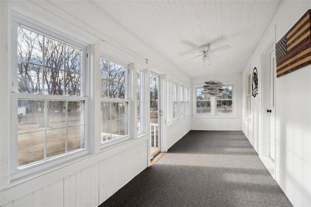 unfurnished sunroom with ceiling fan