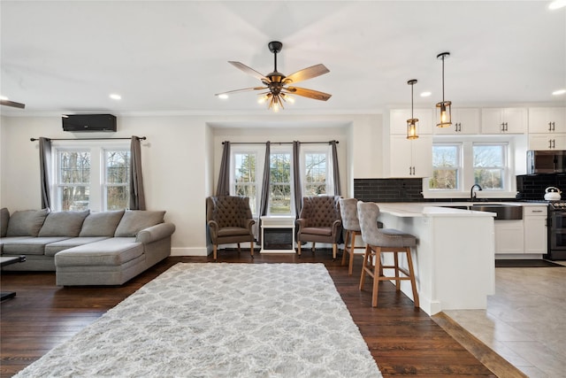 living room featuring crown molding, dark wood-type flooring, and ceiling fan