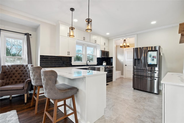 kitchen with appliances with stainless steel finishes, decorative backsplash, a kitchen breakfast bar, white cabinets, and decorative light fixtures