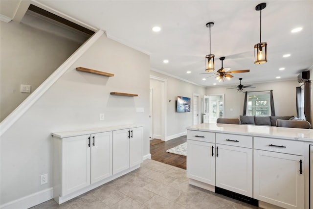 kitchen with ceiling fan, white cabinets, hanging light fixtures, and ornamental molding