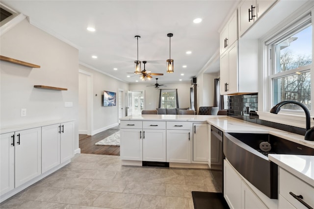 kitchen with sink, white cabinetry, kitchen peninsula, and hanging light fixtures