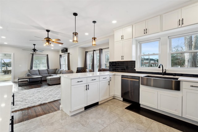 kitchen featuring kitchen peninsula, pendant lighting, dishwasher, and white cabinetry