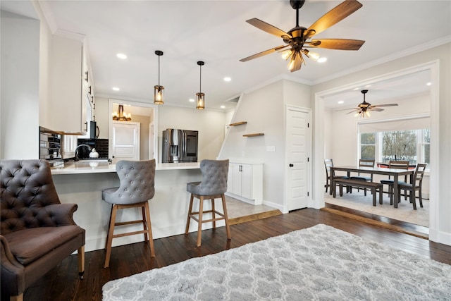 kitchen with a breakfast bar area, white cabinetry, kitchen peninsula, and appliances with stainless steel finishes