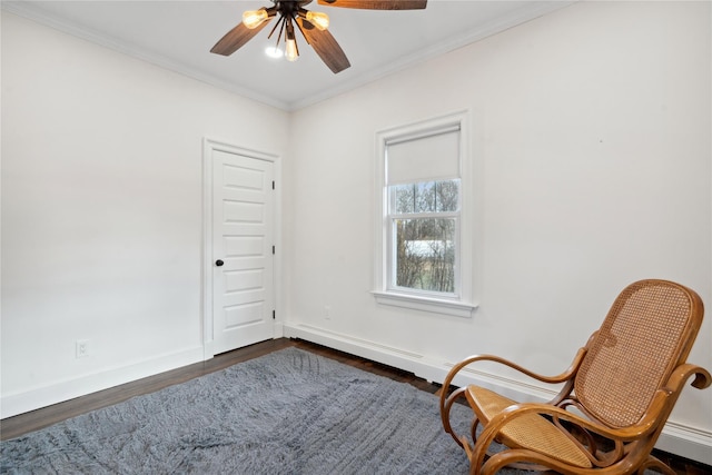 sitting room featuring ceiling fan, crown molding, and dark wood-type flooring