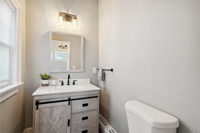 bathroom with vanity, toilet, and baseboard heating