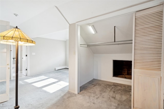 basement featuring a fireplace, a baseboard radiator, and carpet flooring