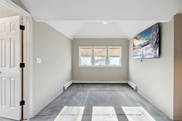 empty room featuring vaulted ceiling, a baseboard heating unit, and carpet floors