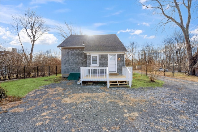 view of front facade featuring a wooden deck and a front lawn