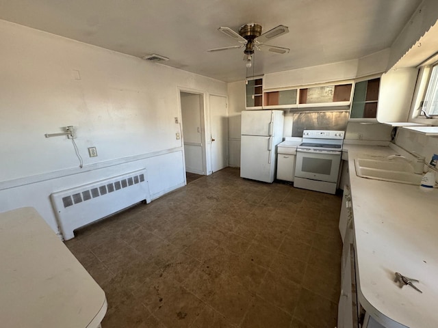 kitchen with sink, white appliances, radiator heating unit, and ceiling fan