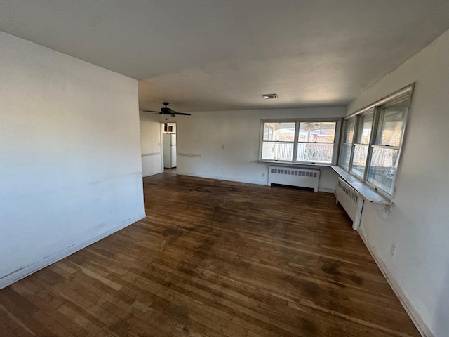 unfurnished room featuring ceiling fan, radiator heating unit, and dark hardwood / wood-style flooring