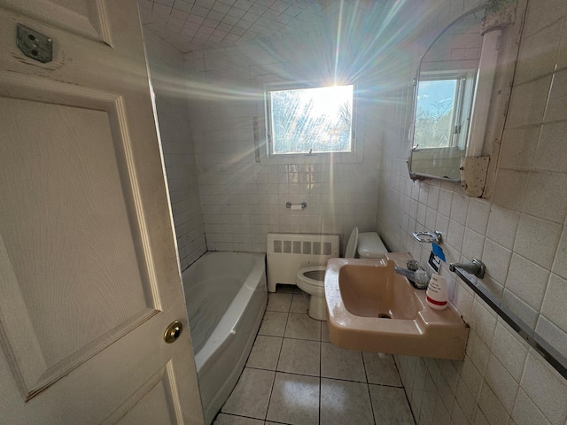 bathroom featuring radiator heating unit, sink, tile patterned flooring, a washtub, and toilet