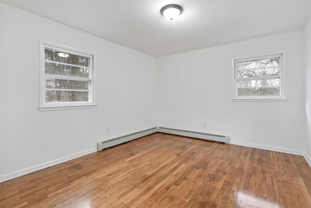 empty room featuring a baseboard radiator and hardwood / wood-style floors