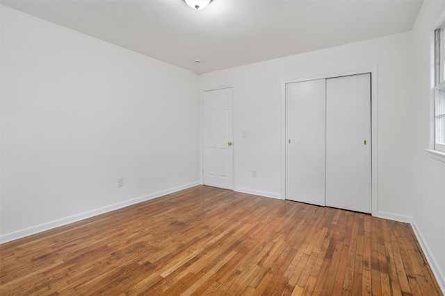 unfurnished bedroom with wood-type flooring and a closet