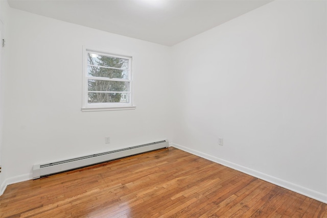 empty room featuring baseboard heating and light wood-type flooring