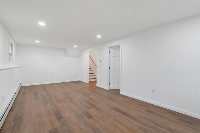 basement featuring baseboard heating and dark hardwood / wood-style floors