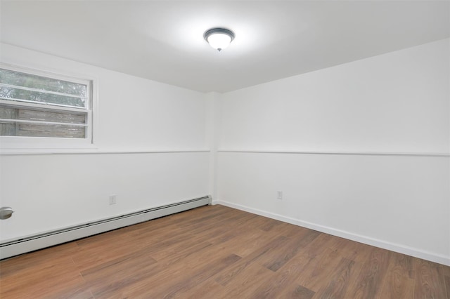 empty room featuring a baseboard radiator and hardwood / wood-style floors