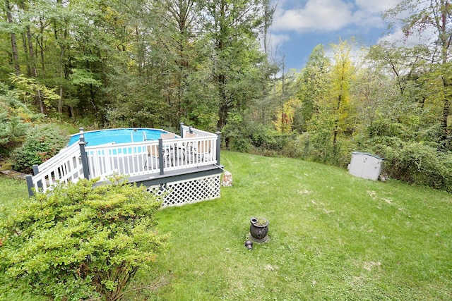 view of yard with a pool side deck and a storage shed