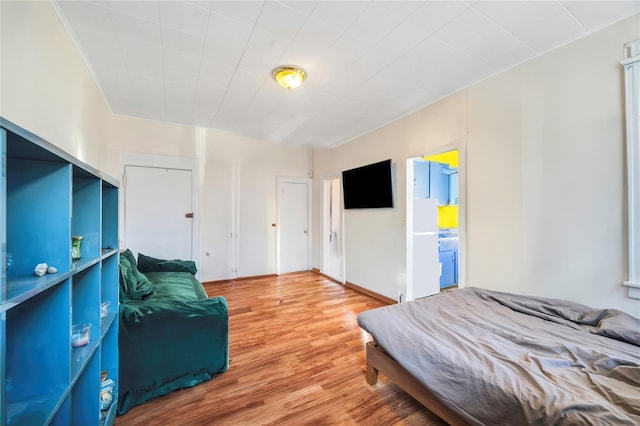 bedroom with hardwood / wood-style floors and ensuite bathroom