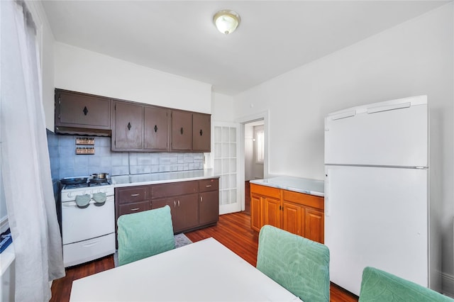 kitchen with decorative backsplash, dark hardwood / wood-style flooring, white appliances, and ventilation hood