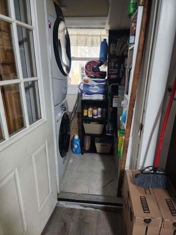 clothes washing area with stacked washer / drying machine