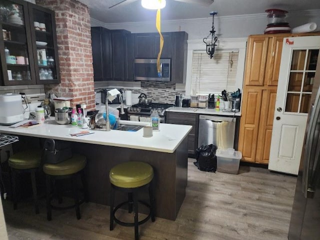 kitchen featuring a breakfast bar, appliances with stainless steel finishes, tasteful backsplash, and hardwood / wood-style floors