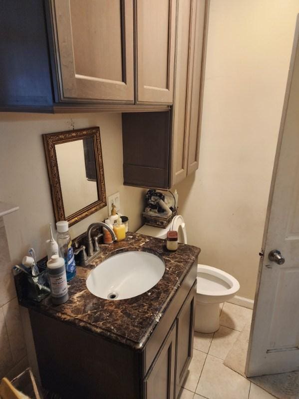 bathroom with tile patterned flooring, vanity, and toilet