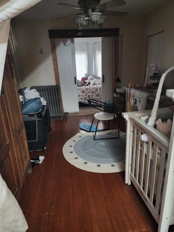 bedroom featuring dark hardwood / wood-style floors, radiator, and ceiling fan