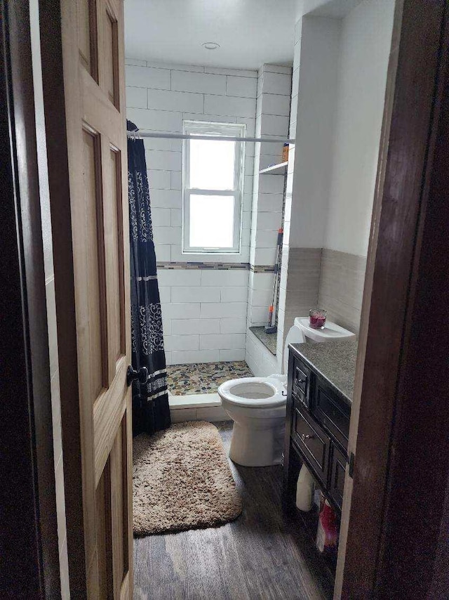 bathroom featuring a shower with curtain, vanity, hardwood / wood-style flooring, and toilet