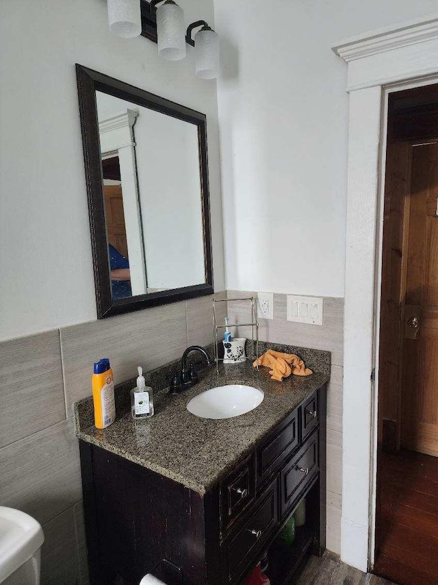 bathroom with vanity, tile walls, and hardwood / wood-style flooring