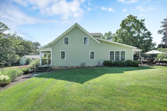 rear view of property featuring a lawn