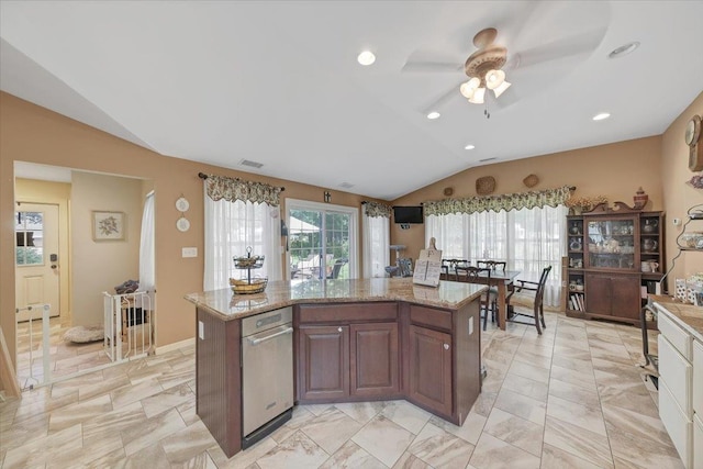 kitchen featuring ceiling fan, a kitchen island, light stone counters, and lofted ceiling