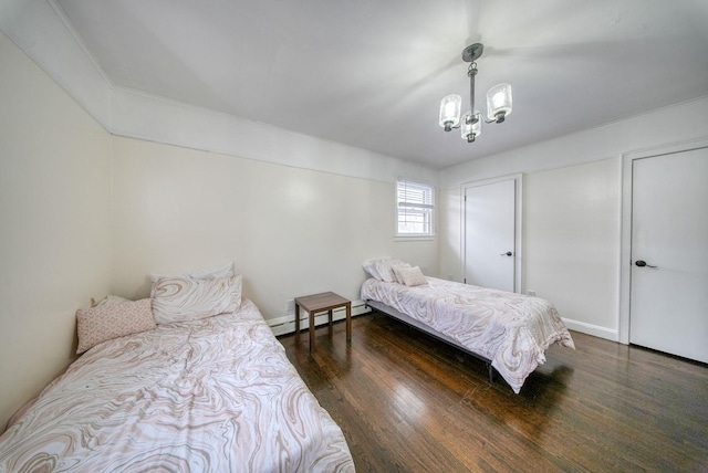 bedroom with dark wood-type flooring, an inviting chandelier, and a baseboard heating unit