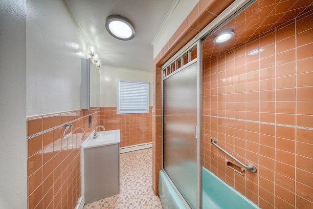 bathroom with vanity, crown molding, bath / shower combo with glass door, baseboard heating, and tile walls