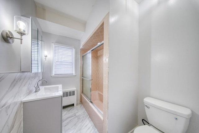 full bathroom with combined bath / shower with glass door, radiator, vanity, tile walls, and toilet