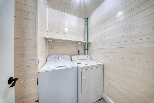 laundry area featuring washer and clothes dryer, wood walls, and wood ceiling