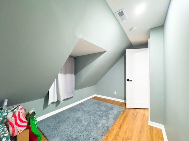 additional living space featuring lofted ceiling and light wood-type flooring