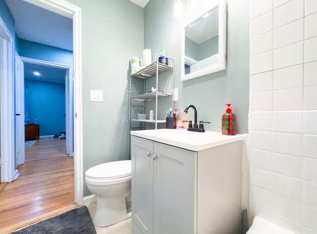 bathroom with hardwood / wood-style floors, vanity, and toilet